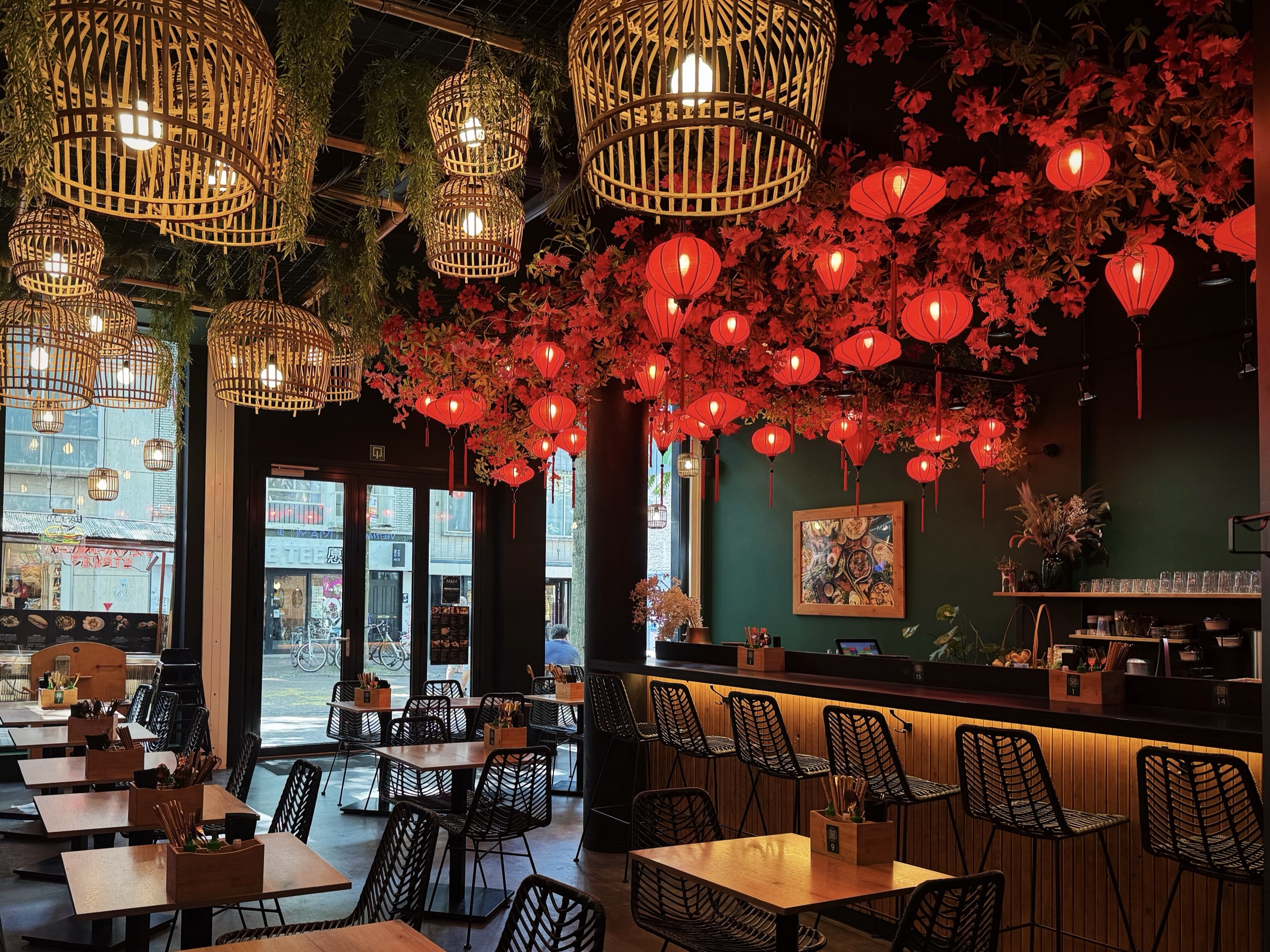 De eetzaal van MẮM met rode lampions en gedekte tafels