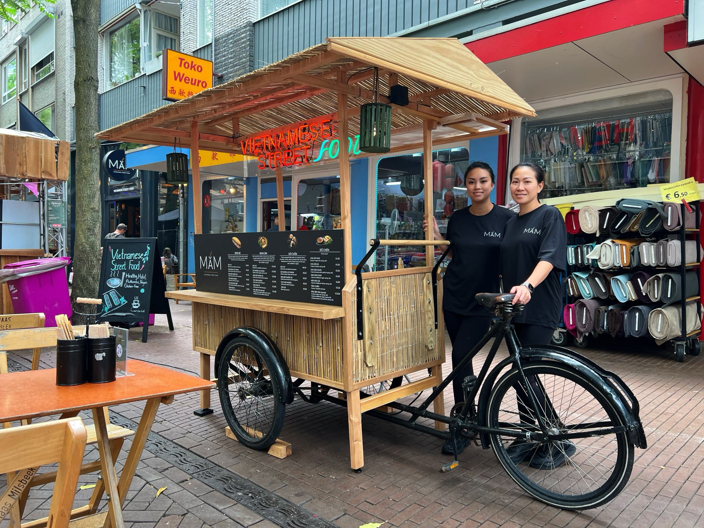 Hiền en Phi-Yến bij hun MẮM-foodkar op straat in Nijmegen